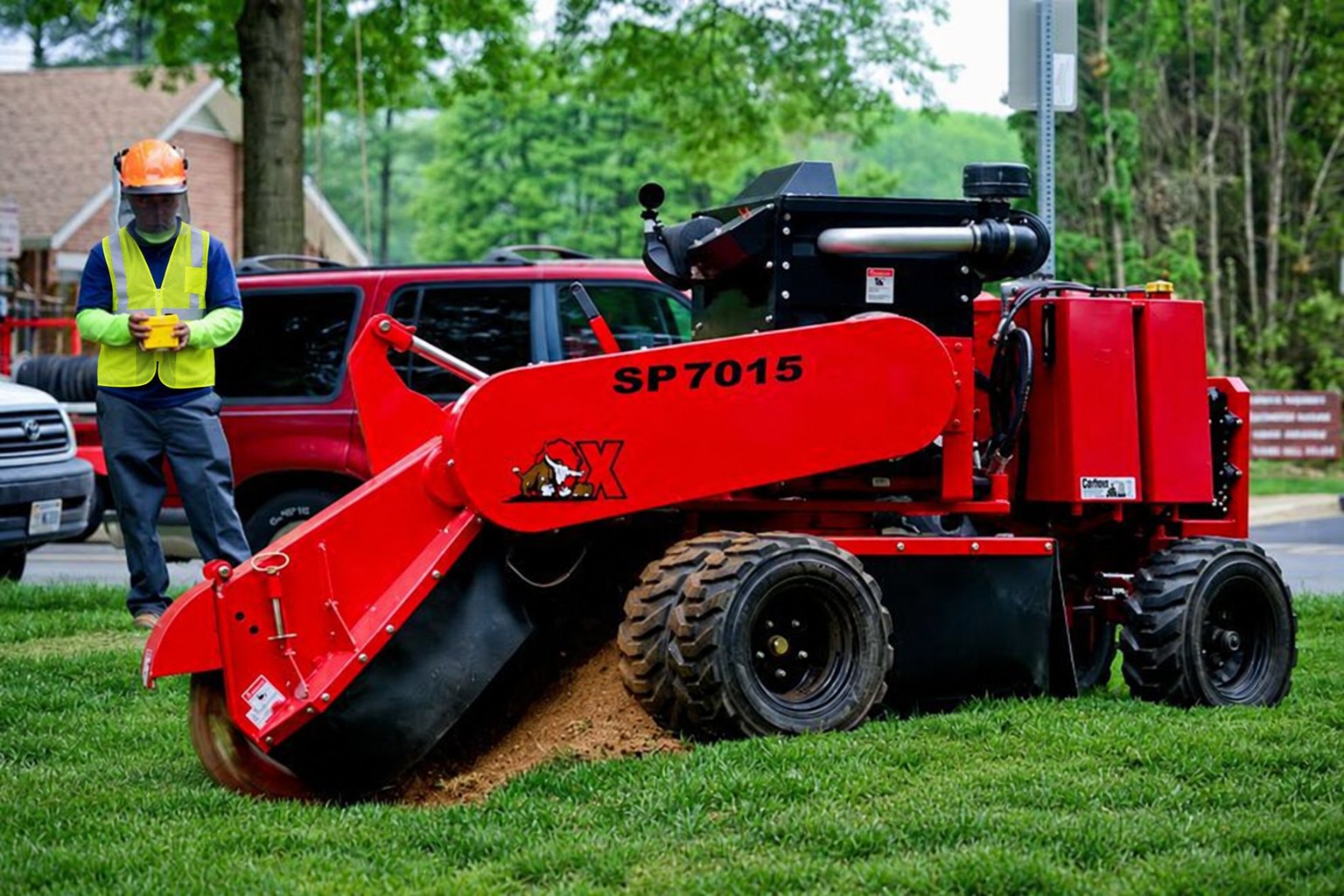 Crew member operating a remote-controlled stump grinder