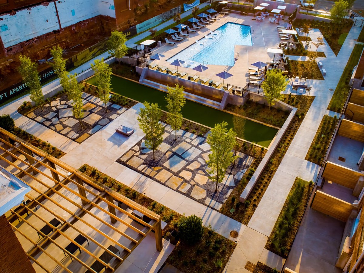Aerial view of a completed multifamily amenity courtyard with stone paths, trees and pool deck