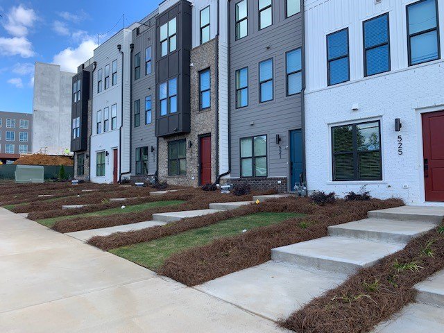 New sod, pine straw and plantings installed along a row of townhomes