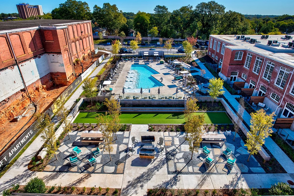 Completed amenity courtyard with stone paths, trees and pool deck at a mill redevelopment