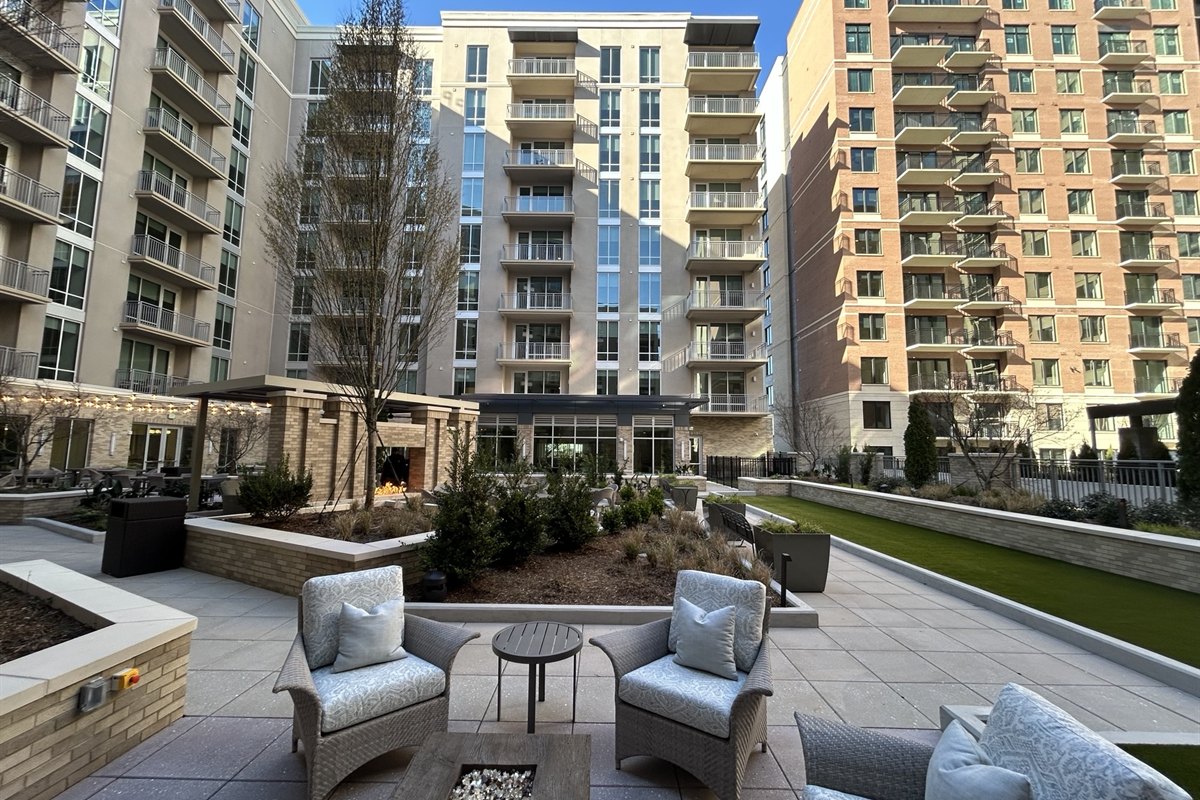 Completed courtyard with raised planters, fire pit seating and lawn at a residential high-rise
