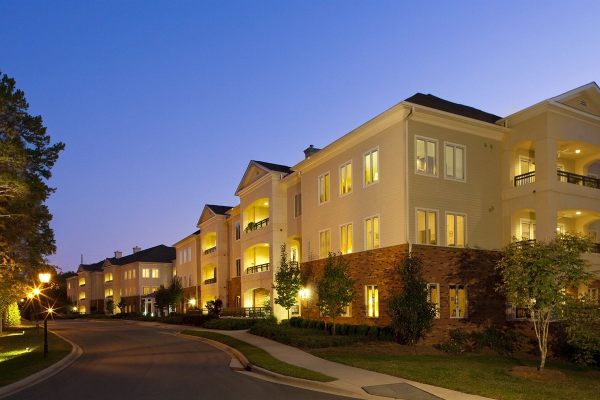 Landscape and path lighting along a residential community drive at dusk