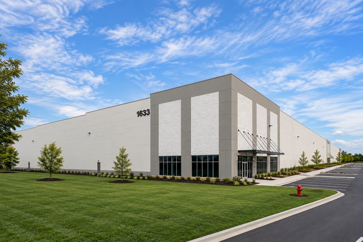 Turf, young trees and foundation plantings along a distribution center frontage
