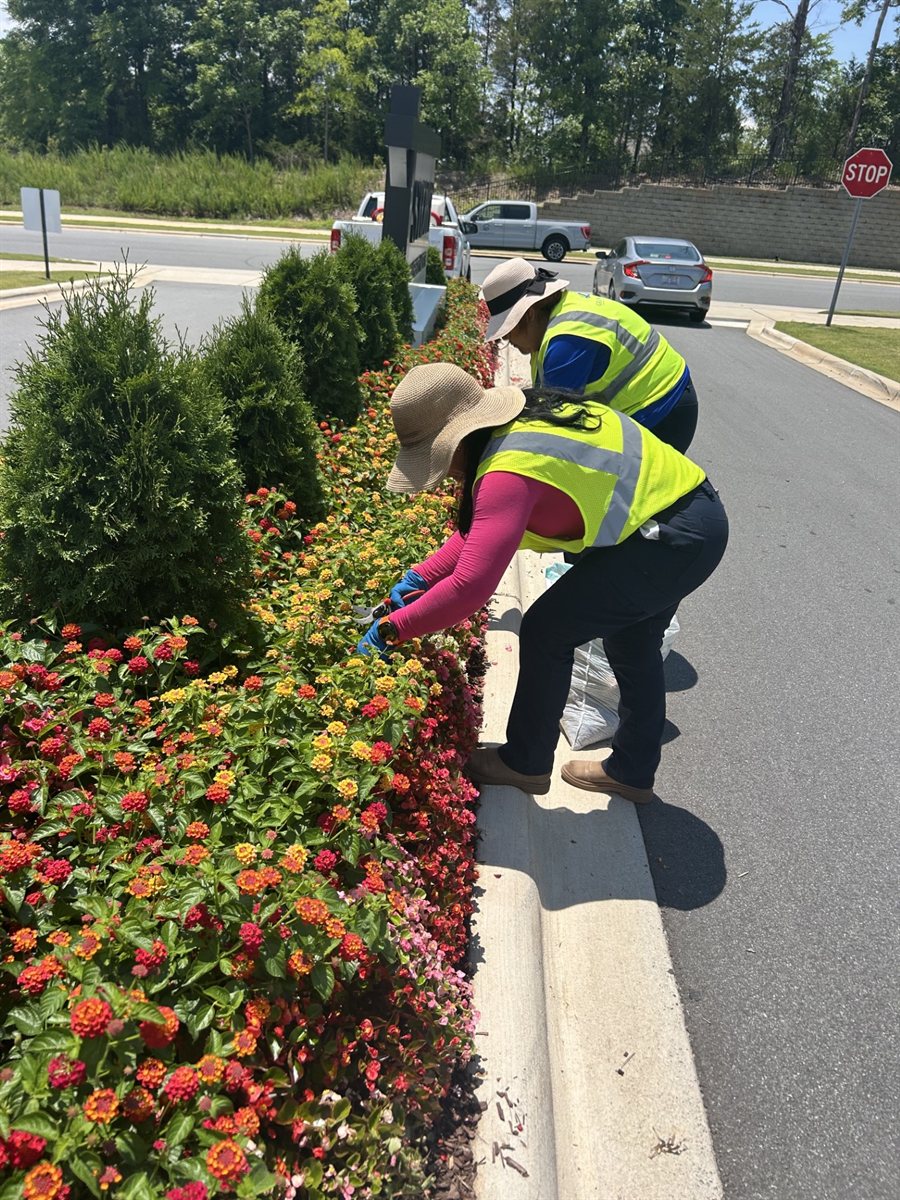 Granite Hills crew members detailing a seasonal color bed at a community entrance