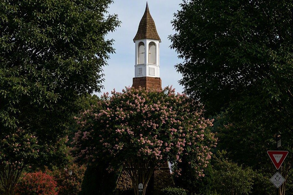 Landscaped community association entrance monument framed by trees