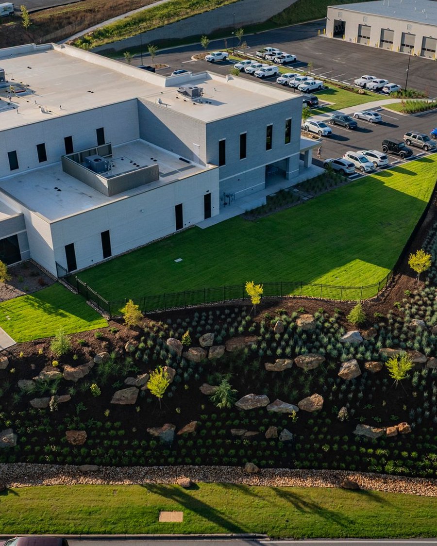Aerial view of an industrial facility with landscaped berm plantings