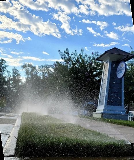 Irrigation system watering a landscaped bed near a Richmond community entrance