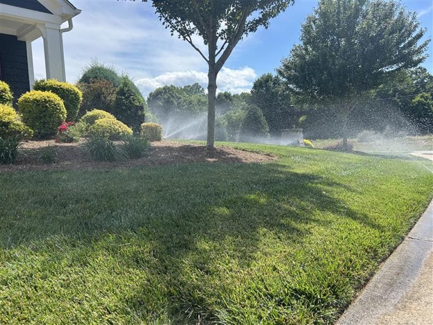 Irrigation system watering a landscaped bed and lawn