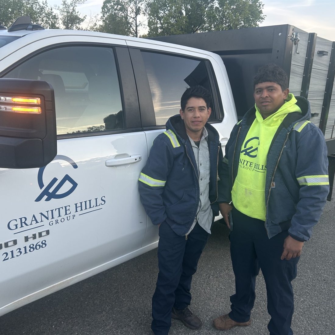 Two Granite Hills team members standing beside a Granite Hills truck.